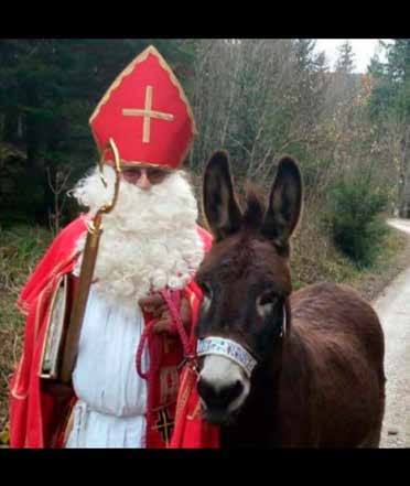 Nikolaus der Tailfinger Nikolausgruppe in rotem Bischofsgewand mit einem Esel